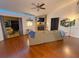 Cozy living room with hardwood floors, a brick fireplace, and access to an outdoor patio, perfect for relaxation at 35058 Whispering Oaks Blvd, Dade City, FL 33523
