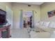A living room with a couch, entertainment stand, and open view into the next room at 35058 Whispering Oaks Blvd, Dade City, FL 33523