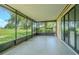 A screened-in patio with tile flooring offers views of the large backyard and landscaping at 35058 Whispering Oaks Blvd, Dade City, FL 33523
