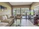Bright sunroom with tiled floor, comfortable seating, and large sliding glass doors to backyard at 35058 Whispering Oaks Blvd, Dade City, FL 33523