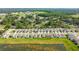 Aerial view shows a planned neighborhood featuring homes encircling a pond, blending community with nature at 36673 Spanish Rose Dr, Dade City, FL 33525
