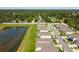 Aerial view displays the neighborhood layout featuring modern homes bordering a scenic pond and lush green landscaping at 36673 Spanish Rose Dr, Dade City, FL 33525