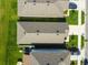 An aerial view of roof tops, and lawns between three homes in a well-maintained neighborhood at 36673 Spanish Rose Dr, Dade City, FL 33525