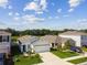 A neighborhood with well-maintained lawns and landscaping, adjacent to a tranquil pond, as seen from above at 36673 Spanish Rose Dr, Dade City, FL 33525