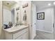 Bathroom vanity with a sink, decor, a large mirror, and access to other rooms of the home at 36673 Spanish Rose Dr, Dade City, FL 33525