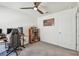 This bedroom features gray carpet, a wood ceiling fan, a bookshelf and a desk setup for working from home at 36673 Spanish Rose Dr, Dade City, FL 33525