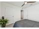 Bedroom features a ceiling fan, a closet and a door, and a bed with neutral decor at 36673 Spanish Rose Dr, Dade City, FL 33525