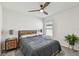 Bright bedroom featuring a ceiling fan, a wooden bed frame and two wooden drawer nightstands with lamps at 36673 Spanish Rose Dr, Dade City, FL 33525