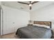 Bedroom features a ceiling fan, a door, and a bed with wooden nightstand with lamps at 36673 Spanish Rose Dr, Dade City, FL 33525