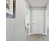 Neutral hallway with gray carpet featuring white doors leading to various rooms in the home at 36673 Spanish Rose Dr, Dade City, FL 33525