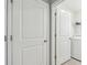 Hallway featuring two doors, one leading to a laundry area with appliances at 36673 Spanish Rose Dr, Dade City, FL 33525