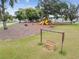 Scenic community playground with a wooden swing set, slide, and picnic tables at 36673 Spanish Rose Dr, Dade City, FL 33525