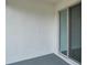 An empty back porch with white walls and gray flooring, with a sliding glass door at 36673 Spanish Rose Dr, Dade City, FL 33525