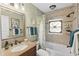 Well-lit bathroom featuring granite countertops, decorative mirror, and a shower-tub combination at 3800 6Th N Ave, St Petersburg, FL 33713