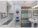 Bathroom with white cabinets, a pedestal sink, and a shower with a decorative curtain at 3800 6Th N Ave, St Petersburg, FL 33713