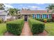 Charming home with a manicured lawn, walkway, black door, and vibrant blue shutters providing a welcoming entrance at 3800 6Th N Ave, St Petersburg, FL 33713