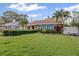 Well-maintained home featuring a lush green lawn, manicured hedge, and vibrant blue shutters enhancing curb appeal at 3800 6Th N Ave, St Petersburg, FL 33713