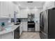 Updated kitchen featuring white cabinets, stainless steel appliances, and herringbone tile flooring at 3800 6Th N Ave, St Petersburg, FL 33713