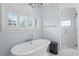 Bright bathroom showcasing freestanding tub, elegant chandelier, shower and shuttered window at 493 Lucerne Ave, Tampa, FL 33606