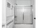 Bathroom with a tub shower combo, sliding glass door, white cabinets and modern hardware at 493 Lucerne Ave, Tampa, FL 33606