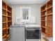 Modern laundry room with side-by-side machines and custom wood shelving creating functional space at 493 Lucerne Ave, Tampa, FL 33606