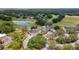 An aerial view of community clubhouse and golf course; features a pond, mature trees, and ample parking at 5182 Championship Cup Ln, Spring Hill, FL 34609