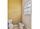 Neutral toned bathroom featuring a commode, bidet, and window with view at 5182 Championship Cup Ln, Spring Hill, FL 34609