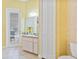 Bright bathroom featuring a vanity, commode, and exterior access to a patio with seating and exterior view at 5182 Championship Cup Ln, Spring Hill, FL 34609