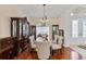 Formal dining room featuring hardwood floors, elegant chandelier, china cabinet, and view to the front entrance at 5182 Championship Cup Ln, Spring Hill, FL 34609
