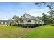 Exterior of home showcasing arched windows, a neatly maintained lawn, and manicured landscaping at 5182 Championship Cup Ln, Spring Hill, FL 34609