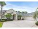 Elegant single-story home boasts a side-entry garage and manicured landscaping featuring palm trees and lush shrubbery at 5182 Championship Cup Ln, Spring Hill, FL 34609