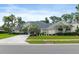 Charming front exterior with lush lawn, mature landscaping, a wide driveway and ample curb appeal at 5182 Championship Cup Ln, Spring Hill, FL 34609