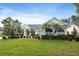 Charming front exterior featuring manicured lawn, mature landscaping, and a wide driveway at 5182 Championship Cup Ln, Spring Hill, FL 34609