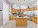 Well-appointed kitchen featuring wood cabinets, granite countertops, and a central island with cooktop at 5182 Championship Cup Ln, Spring Hill, FL 34609