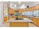 Open kitchen with a granite countertops, a center island cooktop, and wooden cabinetry at 5182 Championship Cup Ln, Spring Hill, FL 34609