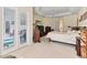 Large main bedroom featuring a tray ceiling, plush carpet, and glass paneled doors to the pool at 5182 Championship Cup Ln, Spring Hill, FL 34609
