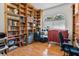 Bright office showcasing extensive built-in bookshelves, natural light, and stylish laminate flooring at 5182 Championship Cup Ln, Spring Hill, FL 34609