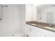 Modern bathroom features double sinks with granite counters, a walk-in shower, and a large mirror at 5518 Blue Azure Dr, Wimauma, FL 33598