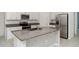Modern kitchen with white cabinets, stainless steel appliances, and granite countertops, ideal for cooking and entertaining at 5518 Blue Azure Dr, Wimauma, FL 33598