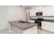 Well-lit kitchen boasts stainless steel appliances, granite countertops, and a large island with bar seating at 5518 Blue Azure Dr, Wimauma, FL 33598