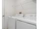 Efficient laundry area featuring a washer, dryer, and overhead shelving for storage and organization at 5518 Blue Azure Dr, Wimauma, FL 33598