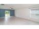 Open-concept living area with sliding glass doors, tile floors, and lots of light at 5518 Blue Azure Dr, Wimauma, FL 33598