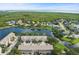 Aerial view of the townhome community overlooking a beautiful lake and green landscape at 568 Shoreham Ne Ct, St Petersburg, FL 33716