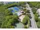 Aerial view showcasing tennis courts, a pool, and a basketball court nestled in lush greenery at 568 Shoreham Ne Ct, St Petersburg, FL 33716