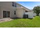 Private backyard with green grass, patio, sliding glass door, and white fencing offers space for outdoor activities at 568 Shoreham Ne Ct, St Petersburg, FL 33716