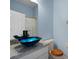 Stylish bathroom with a vibrant blue bowl sink, granite counters, and updated fixtures at 568 Shoreham Ne Ct, St Petersburg, FL 33716