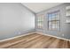 Bright bedroom features wood-look flooring and two windows with wood trim at 568 Shoreham Ne Ct, St Petersburg, FL 33716