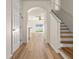 Bright foyer featuring wood-look flooring, staircase, and archway to living area at 568 Shoreham Ne Ct, St Petersburg, FL 33716