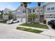 Gray two-story townhome featuring a white garage door and manicured landscaping at 568 Shoreham Ne Ct, St Petersburg, FL 33716
