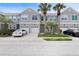 Gray townhome with a driveway, white garage door, and palm trees at 568 Shoreham Ne Ct, St Petersburg, FL 33716